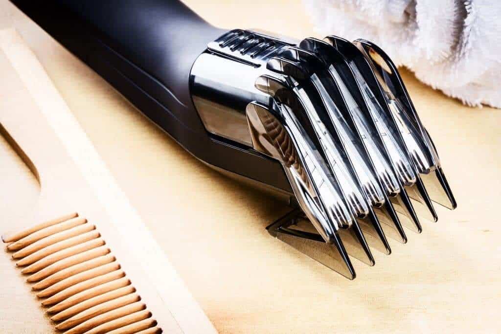 Setting with hair clipper and wooden comb. Closeup shot