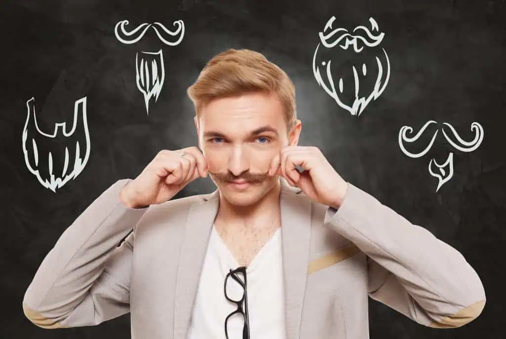 Man choose facial hair style, beard or mustache. Barber shop haircuts choice. Male fashion, various beard styles drawings at blackboard. Stylish young guy think of changing hairstyle. Man portrait